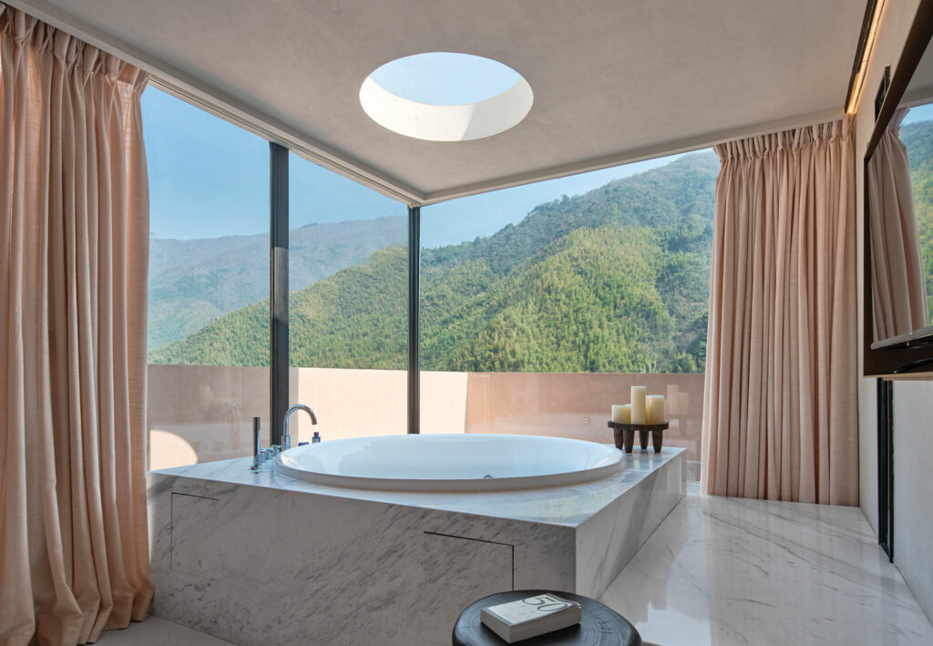 bathroom with white marble tub, skylight and windows to outside