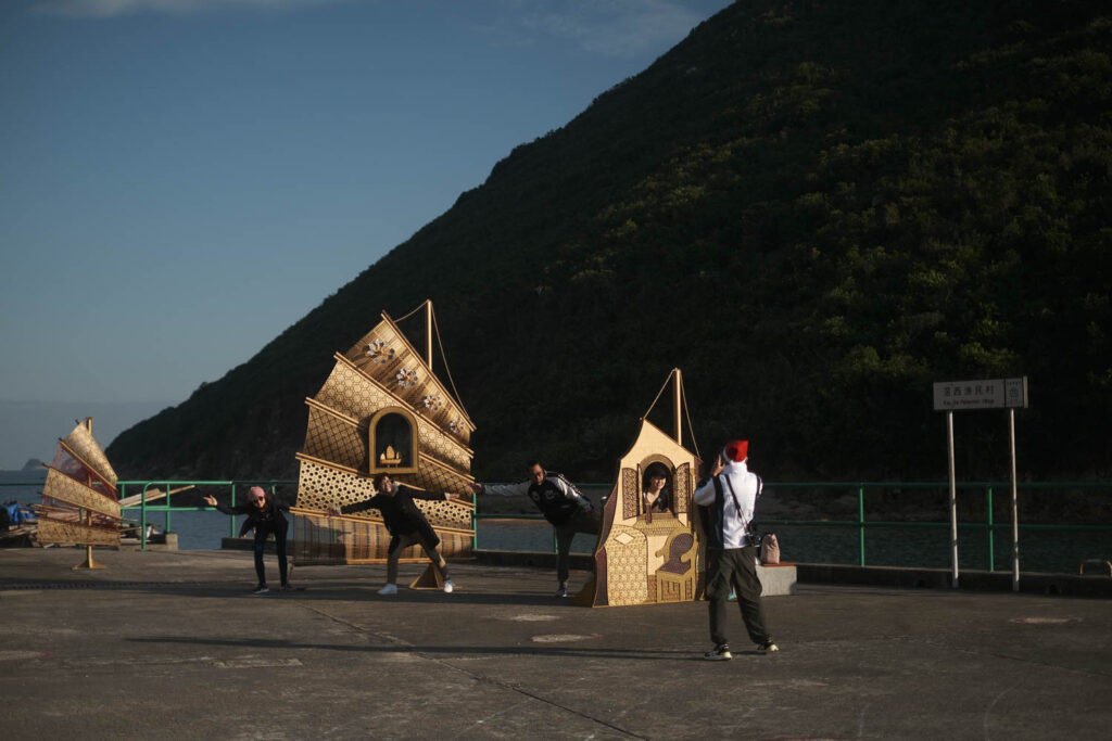 people on stage with paper fans that are in the shape of a boat in project by Sarah Mui