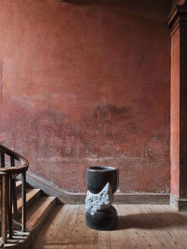 black planter in the stairwell against a rust background