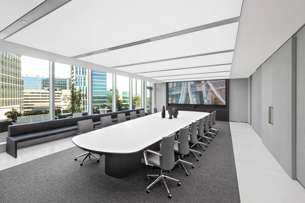 all-white boardroom with long white table and high ceilings