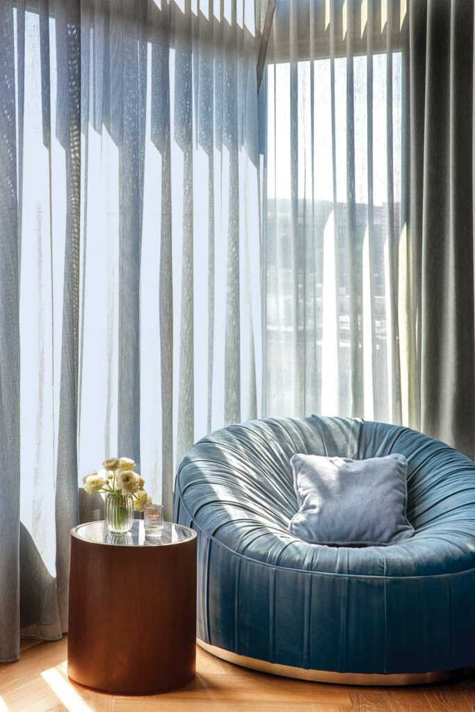 blue velvet lounge chair in front of blue drapes in lounge