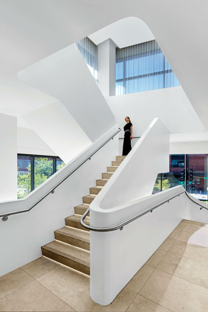 white stairway with steel handrails connecting the hotel lobby to the conference center