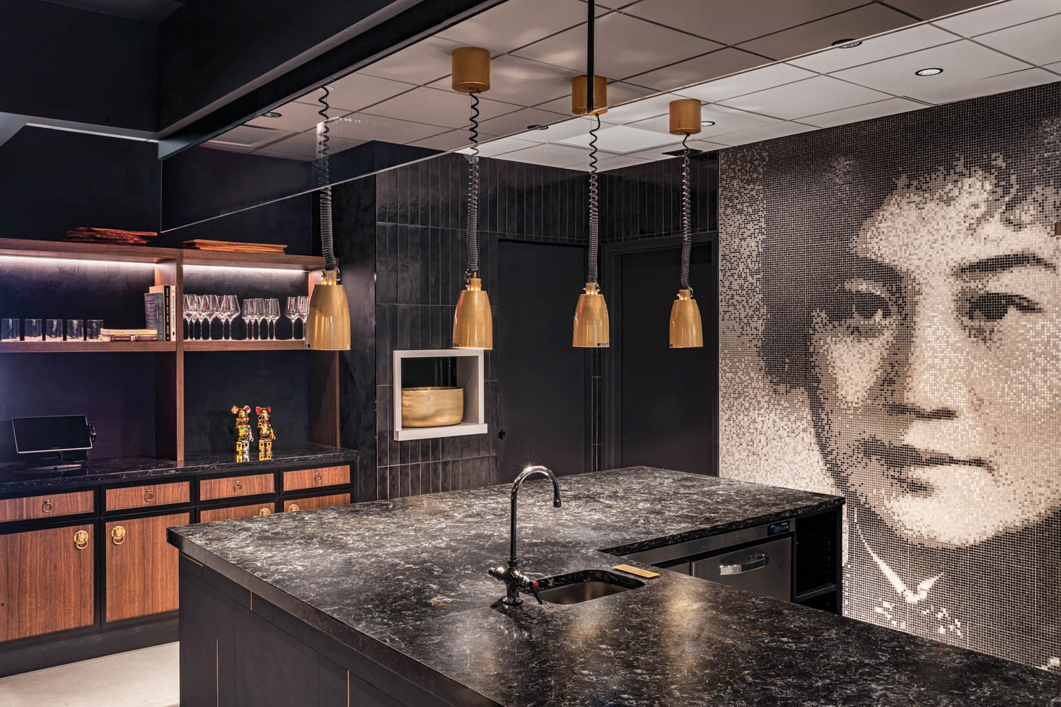 restaurant with black tile walls, black island and artwork of Chinese woman in background