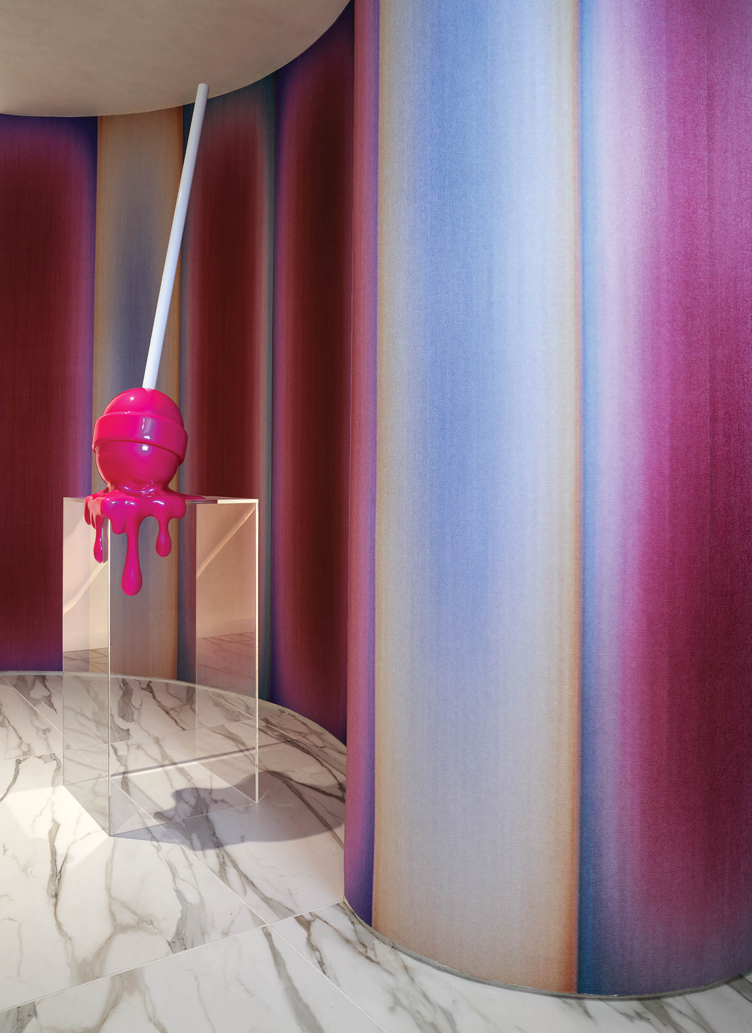 hallway entry with pink walls and a large pink lollipop sculpture in middle