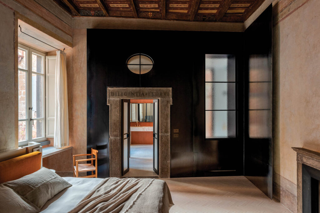 bedroom with dark blue walls and tan flooring