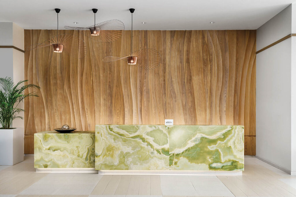 reception area with wooden background and patterned green desk