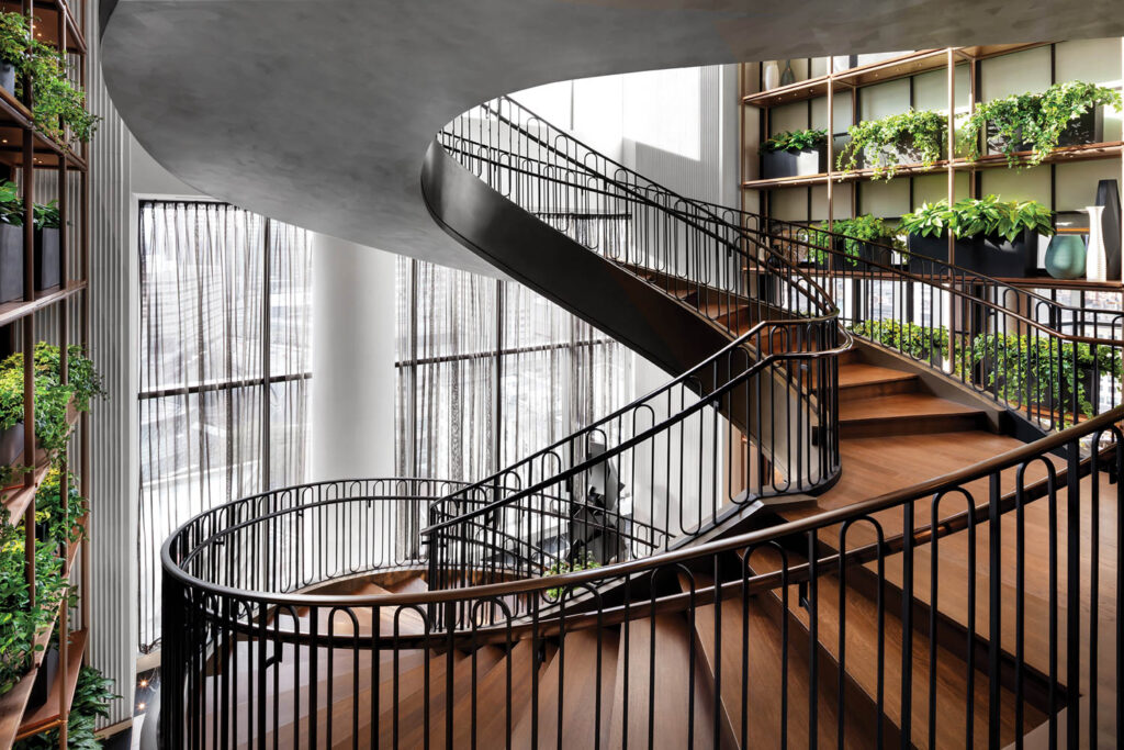 long curvy stairway with black iron rails