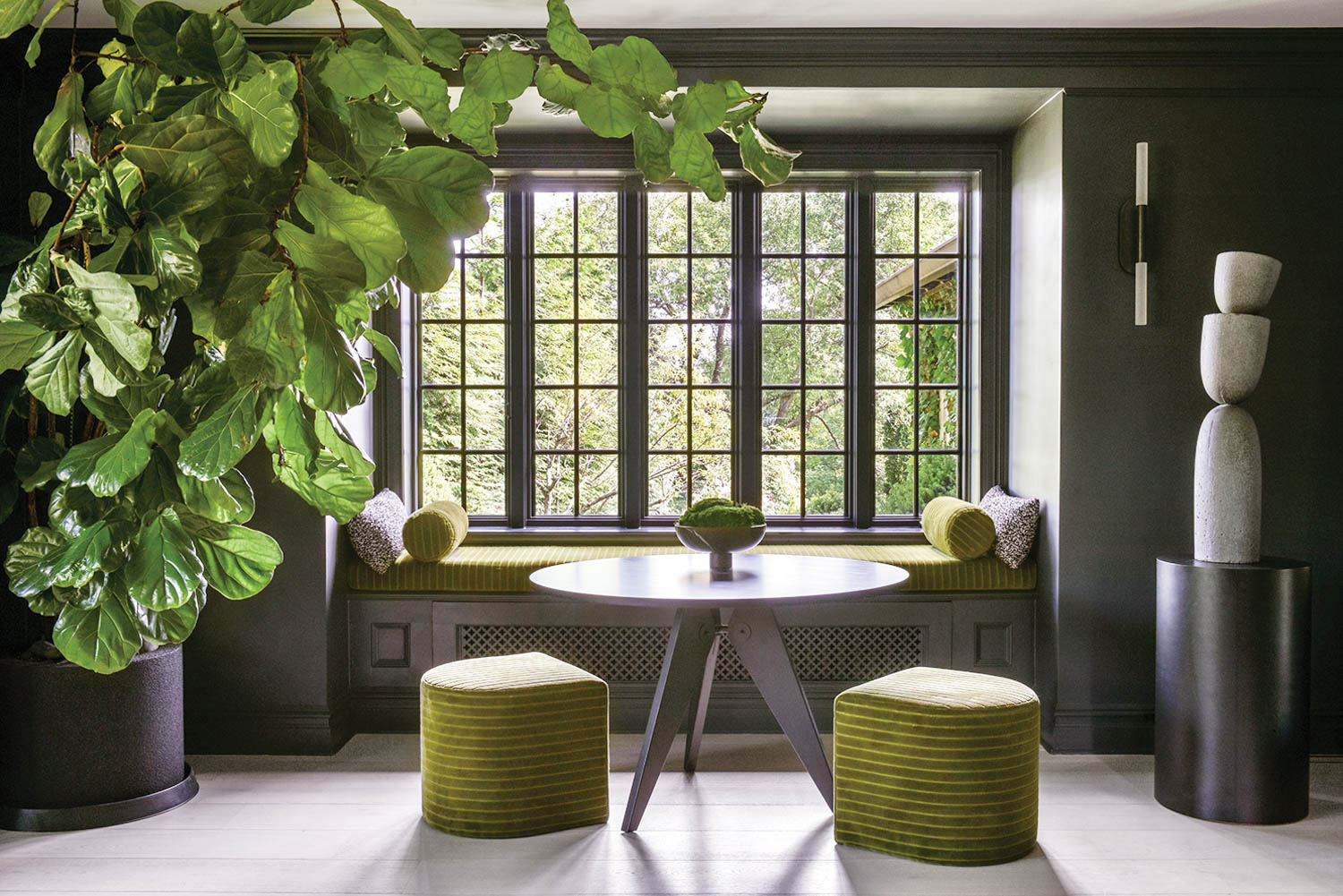 a dining nook with a leafy plant and expansive window