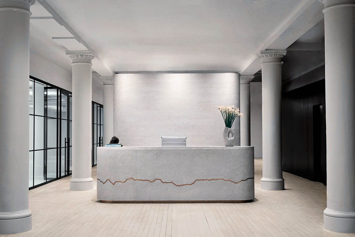 reception area with white marble columns and black frame windows