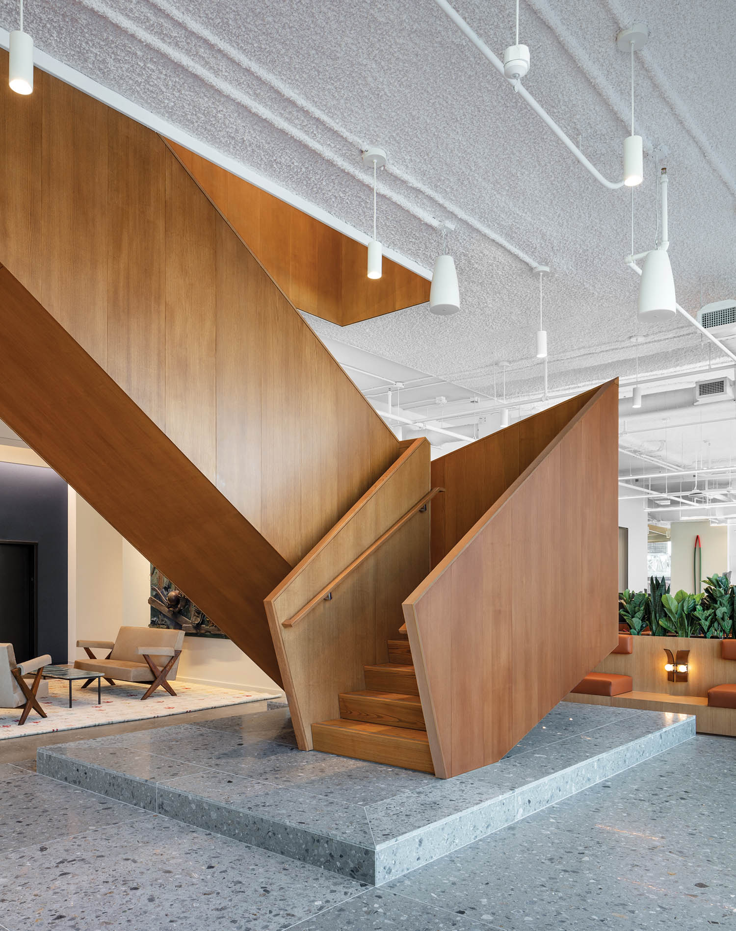 wooden staircase in the center of the room on a concrete panel