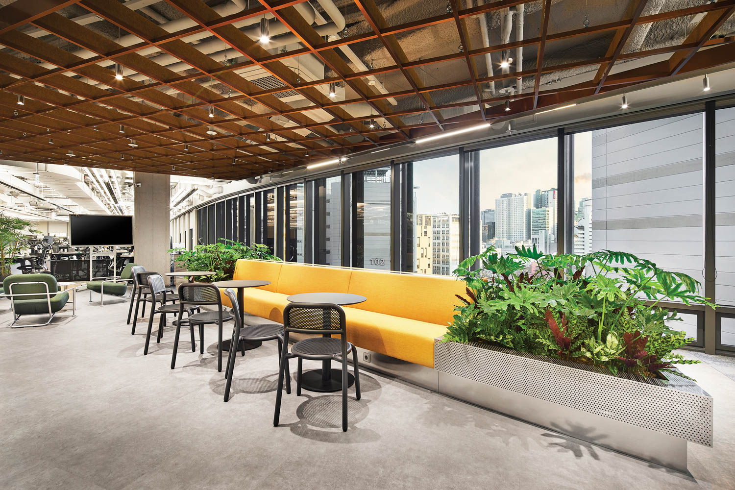 dining area with bright yellow bench and greenery