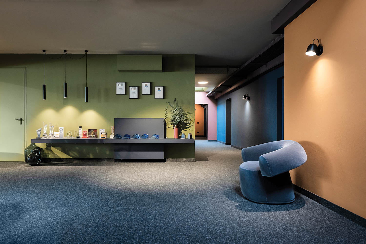 lounge with blue carpeting, green walls and furnishings