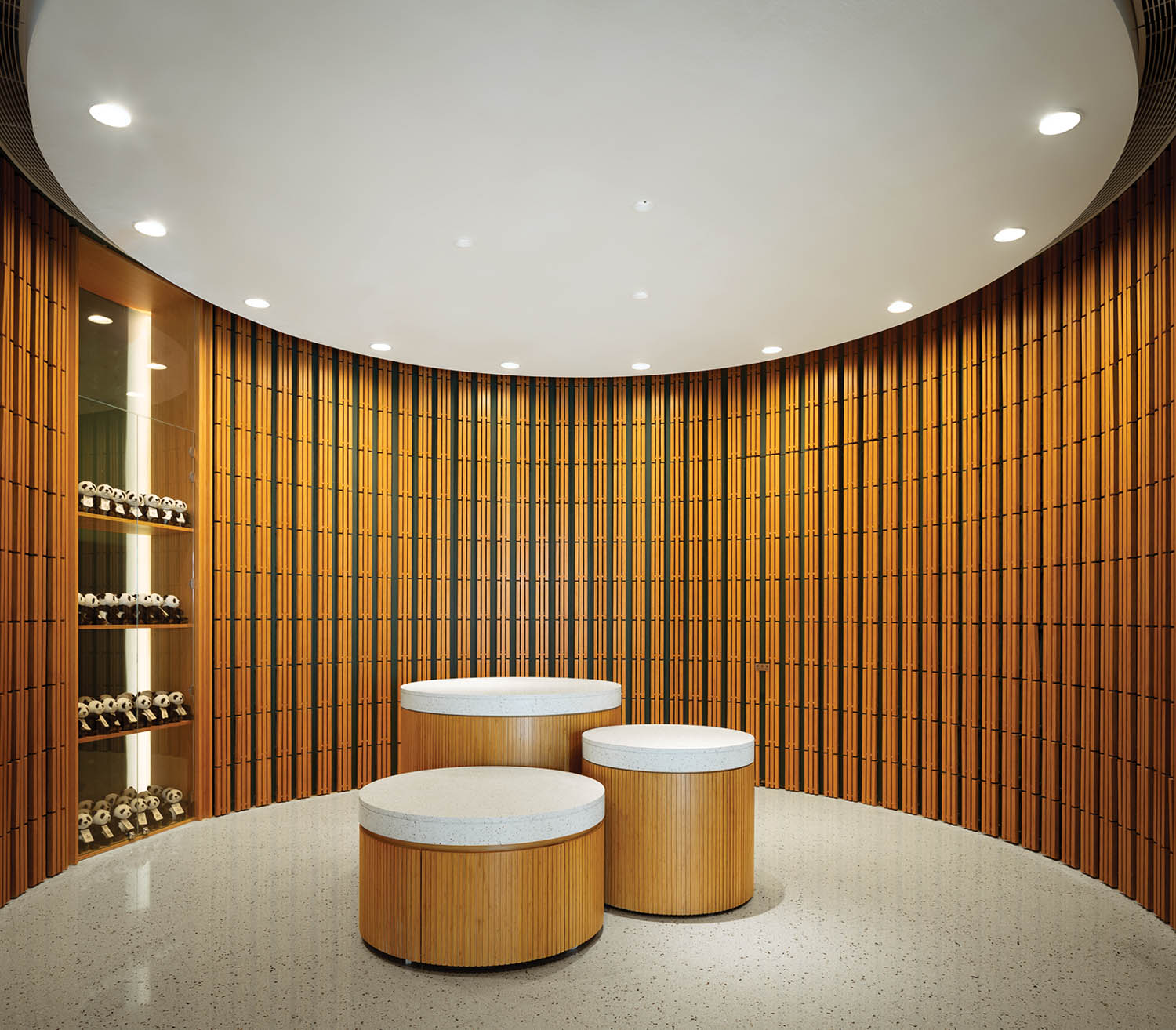 room with slatted bamboo walls, round circular ceiling lights and benches made of slatted bamboo