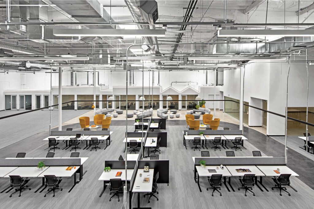 a mezzanine overlooks an open work space with clusters of desks