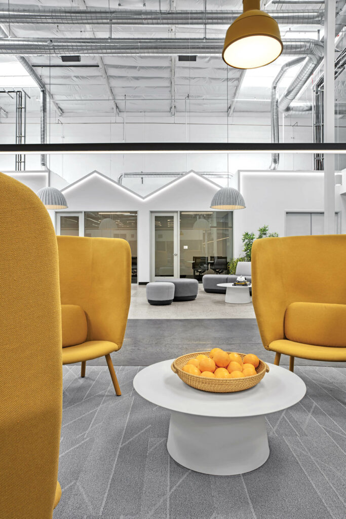 orange lounge chairs with high backs near a bowl of oranges