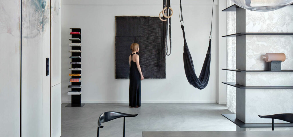 woman standing near a black hammock in a black dress