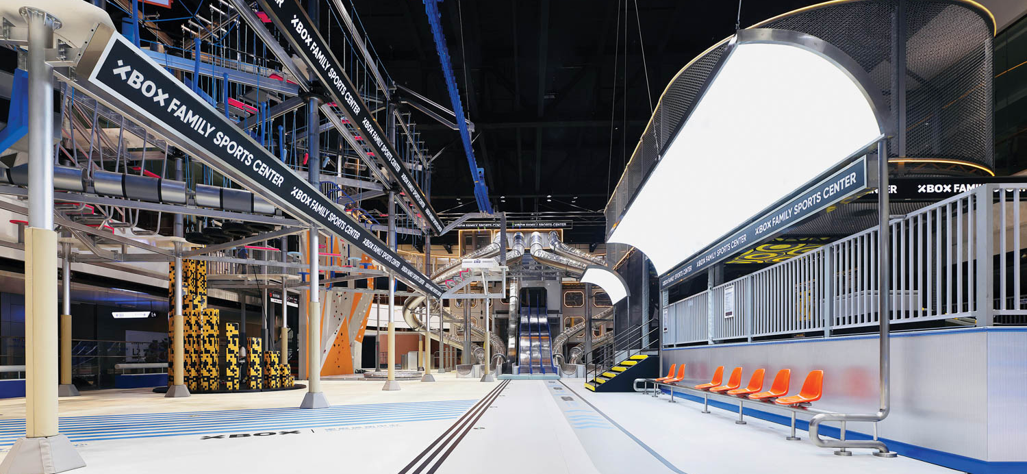 interior of a sports center with a trampoline, slides and bright lights