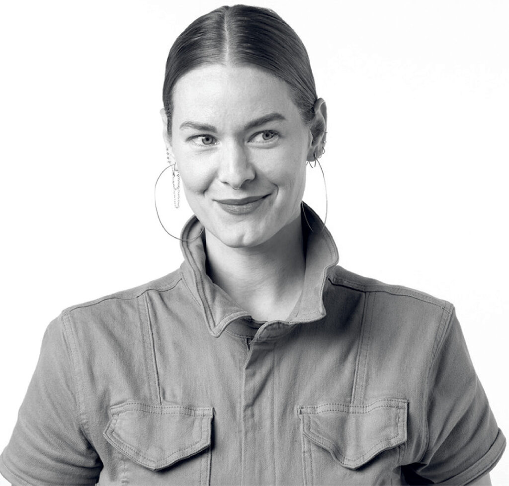 A woman in a denim shirt and earrings