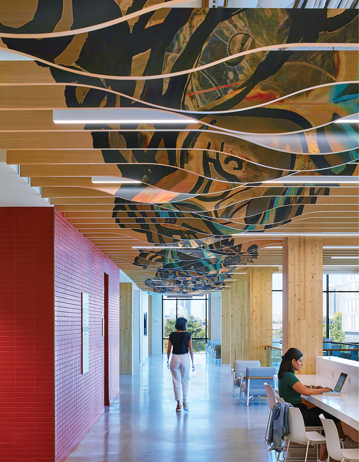 A large mural of a woman walking down a long hallway