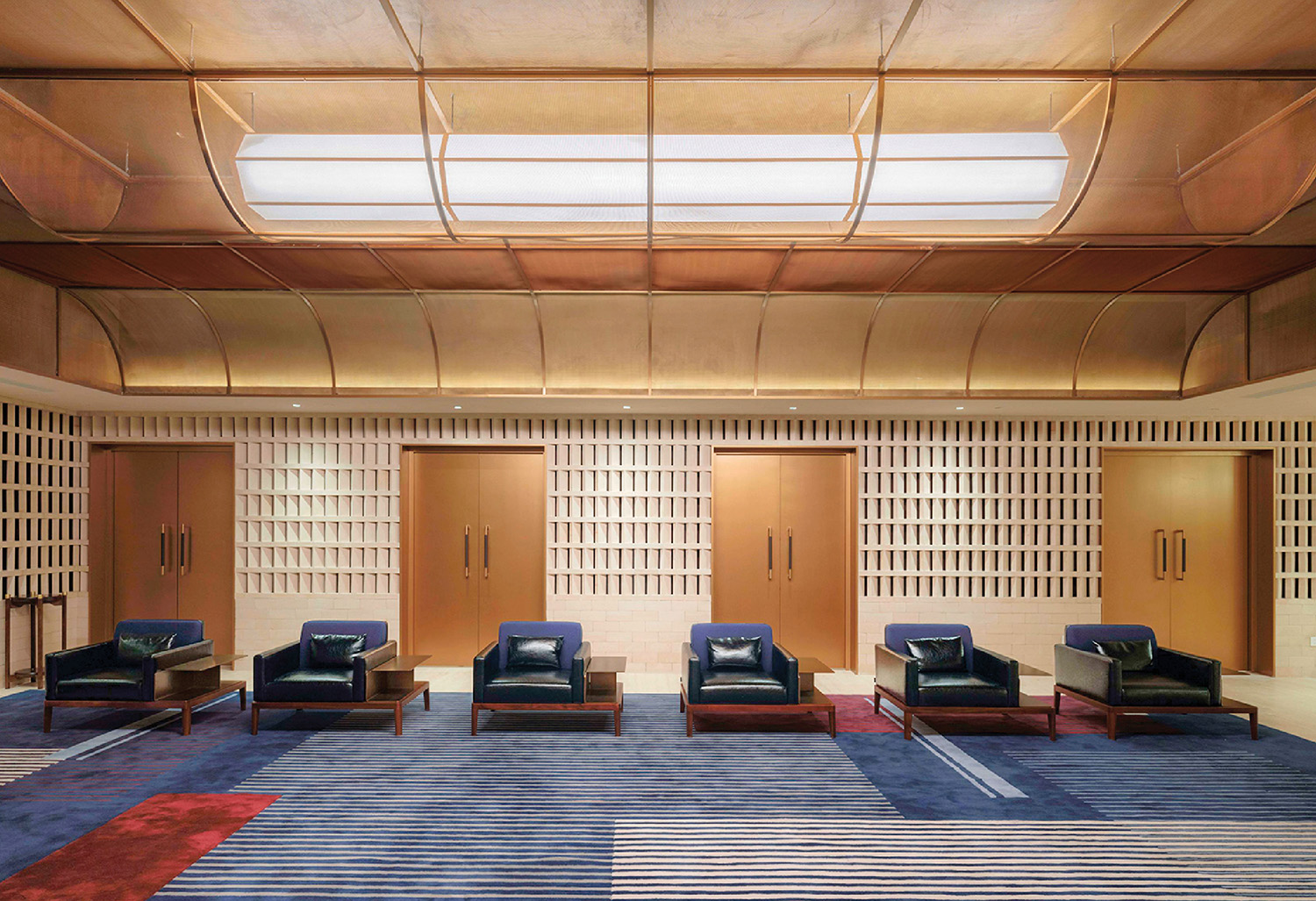 A room with a blue rug and chairs