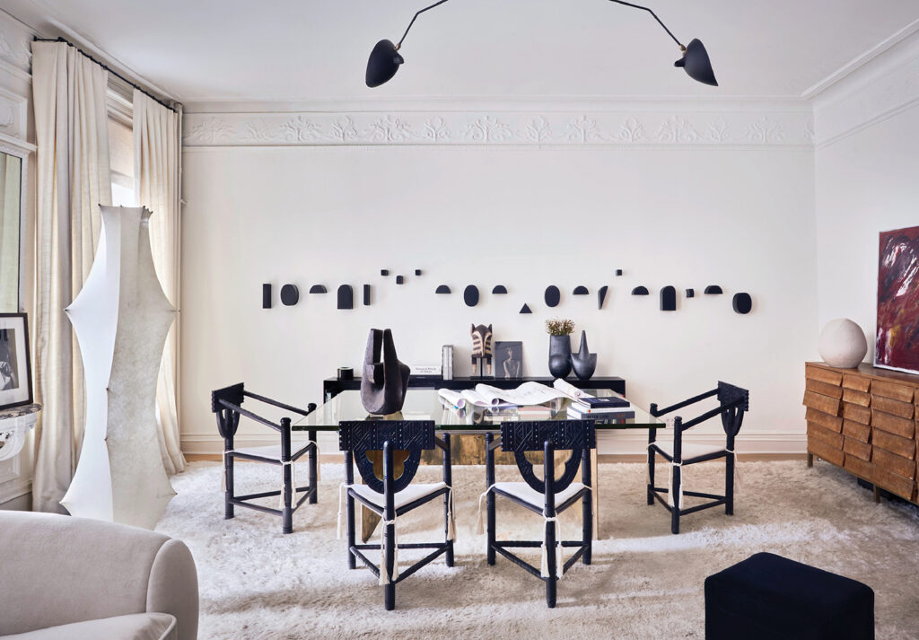 a room with a table and chairs and a large mirror