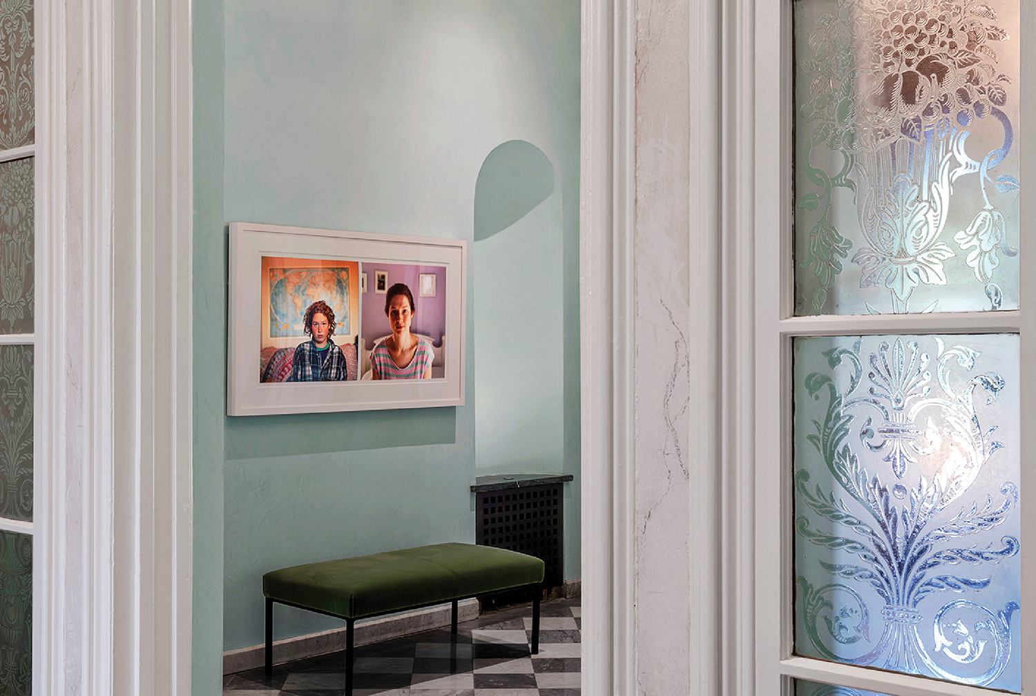 A room with a bench and a picture of a woman