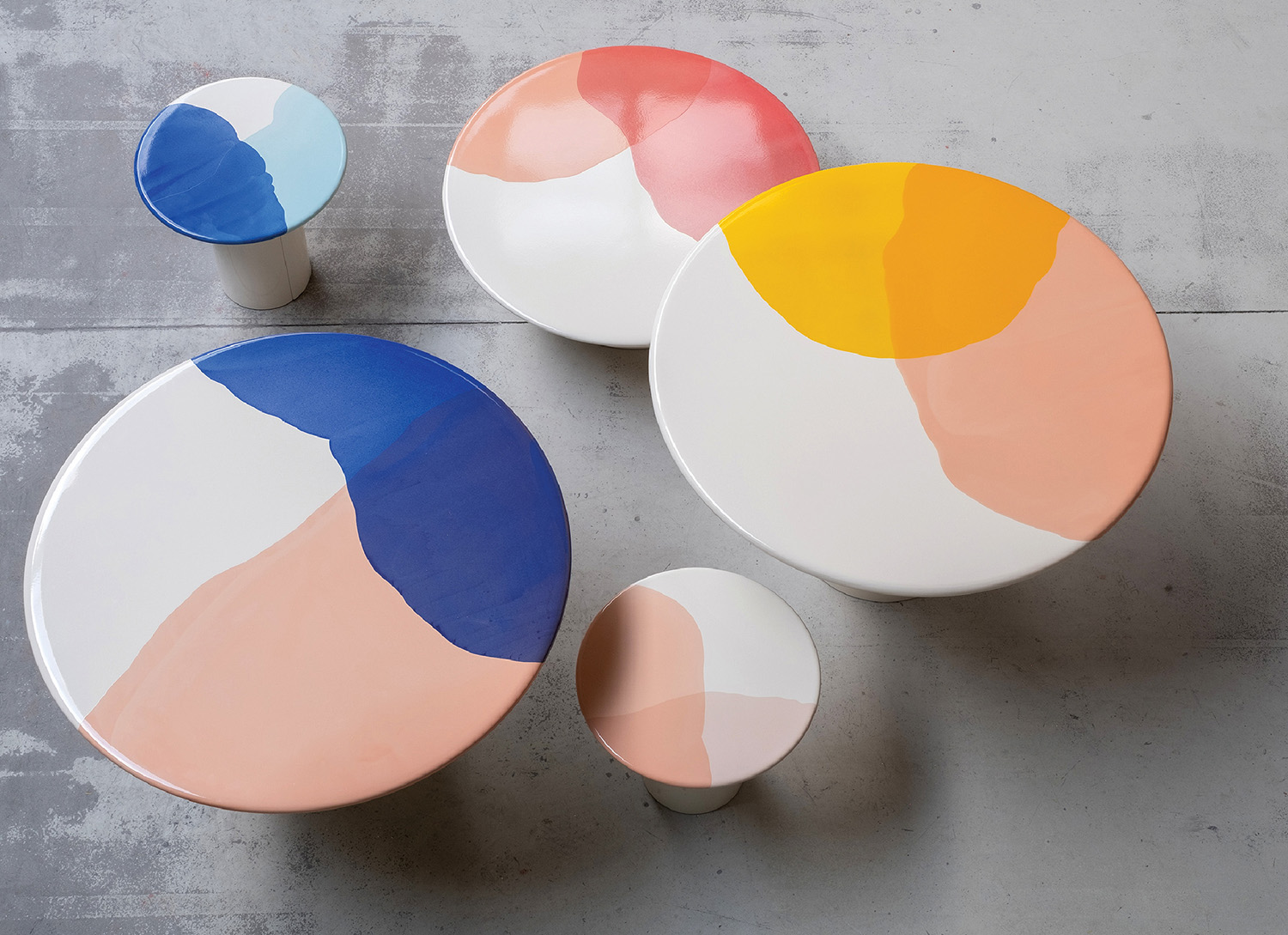 Three colorful plates on a concrete surface