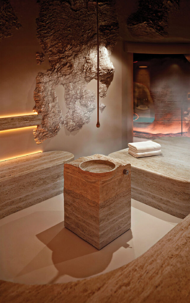 A room with a fireplace and a large stone bench