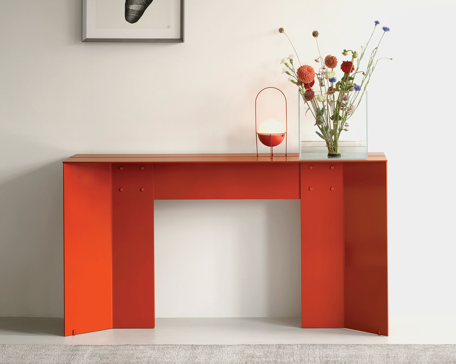 A red table with flowers and a vase