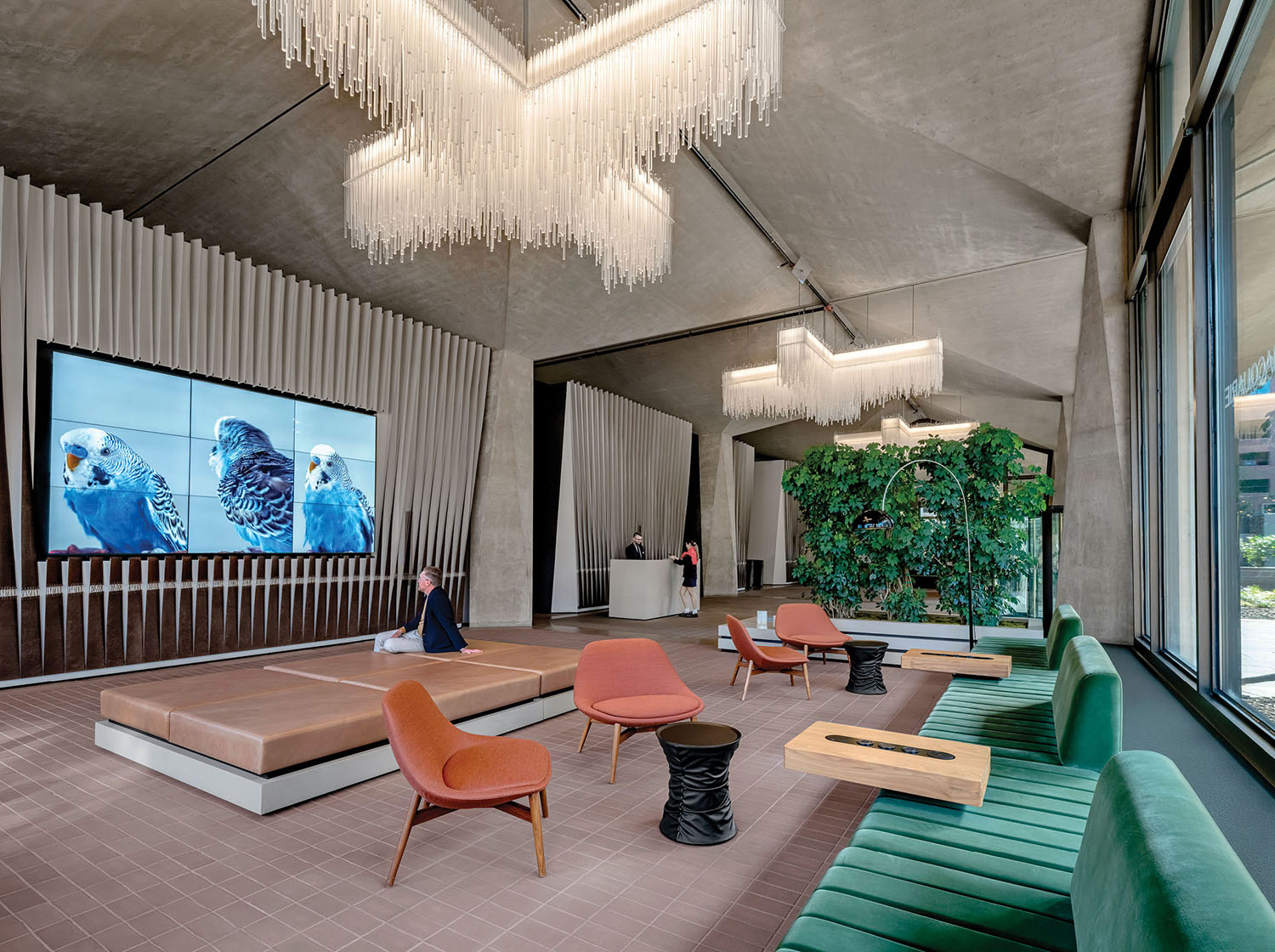 A living room with a large screen on the wall in office by Rapt Studio