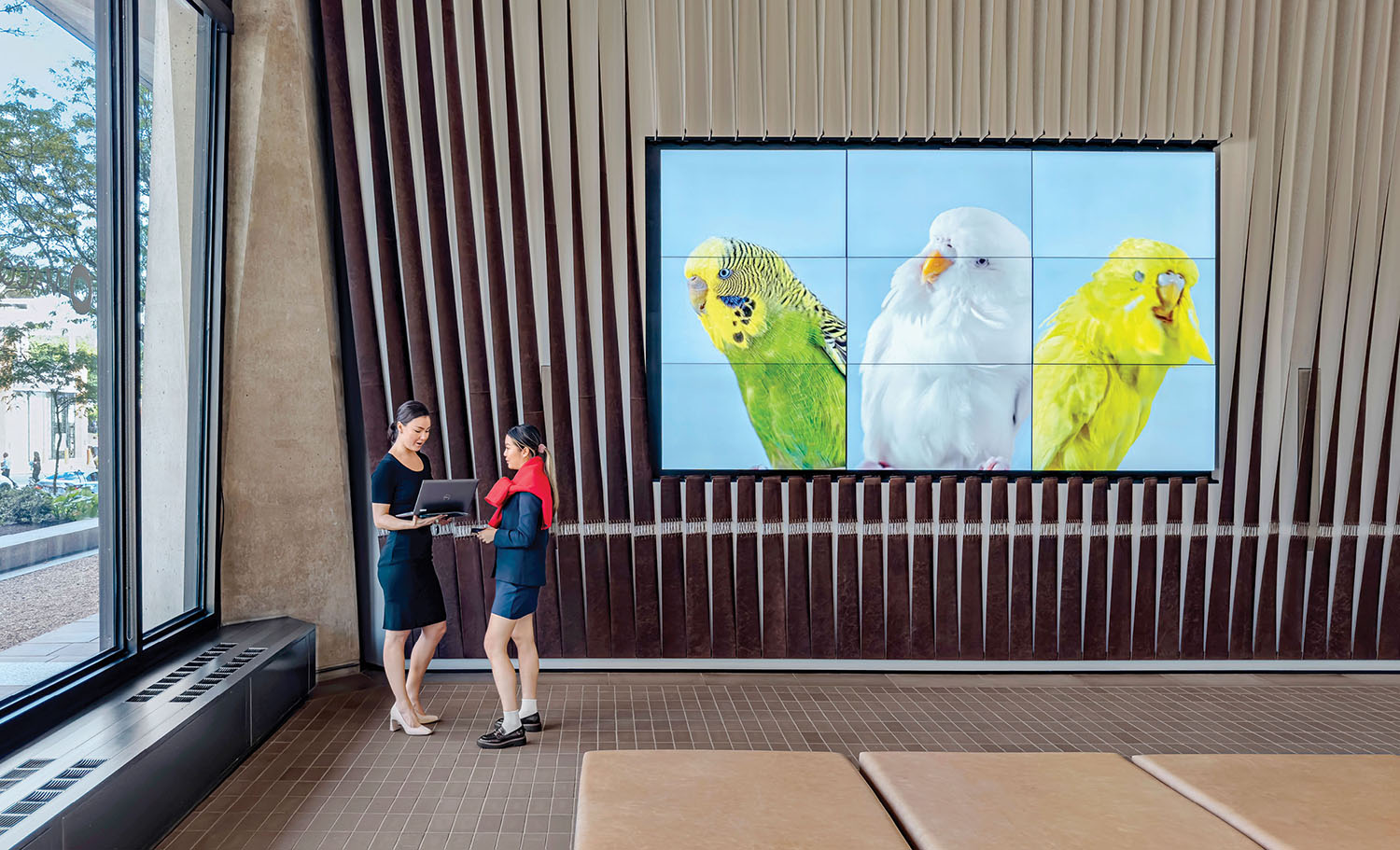 A woman standing in front of a large screen in office by Rapt Studio