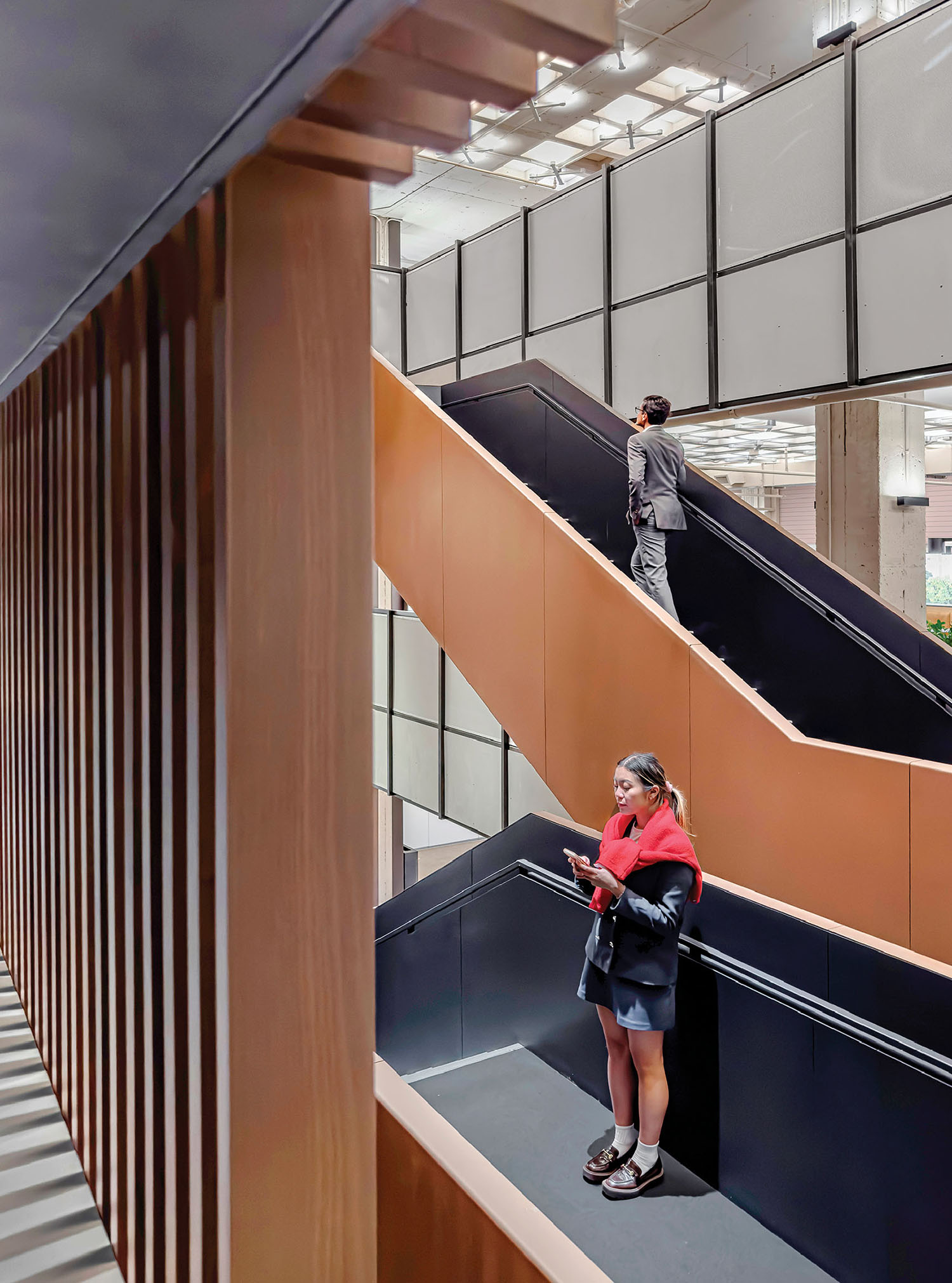A woman is standing on a stair in a building