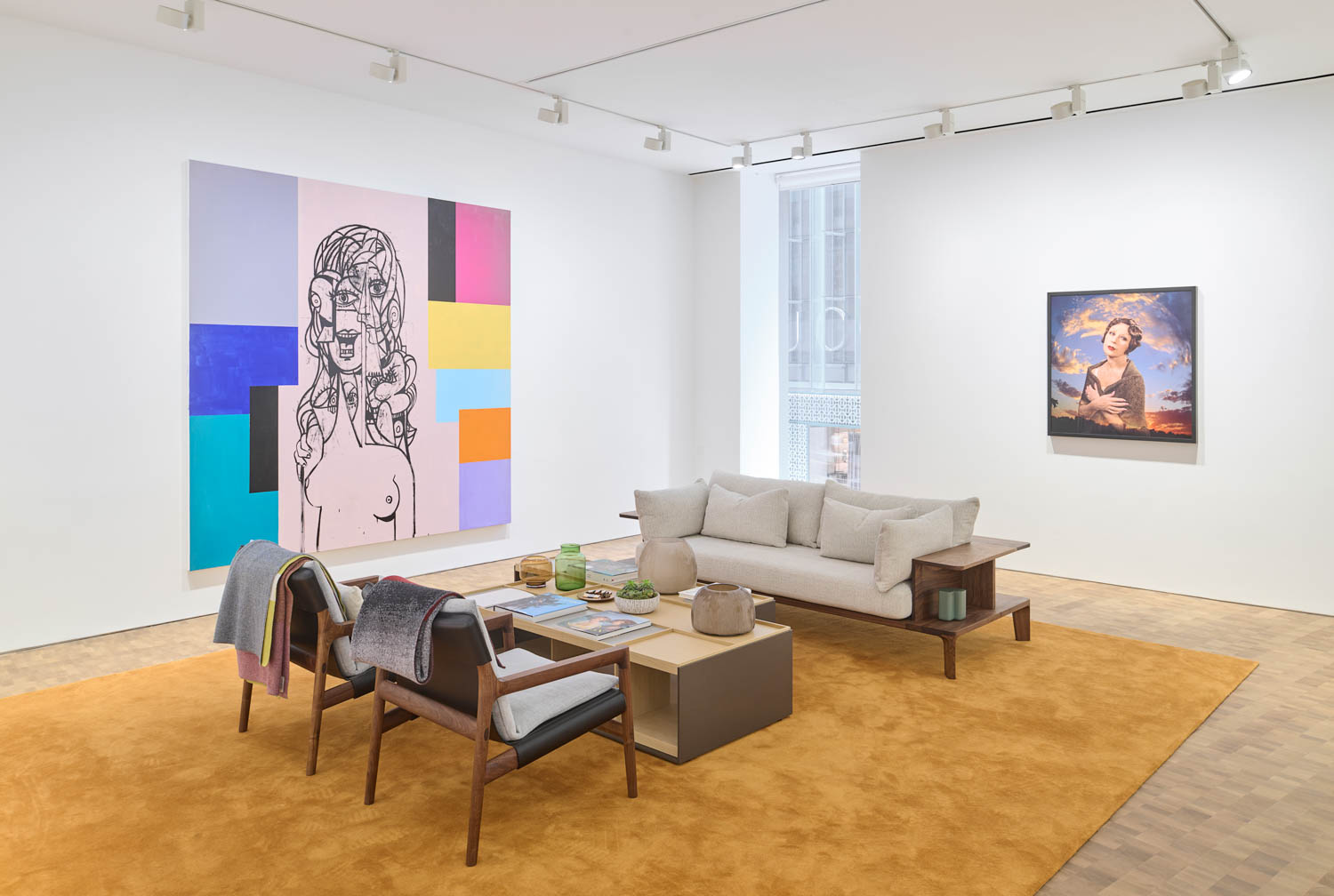 gallery space with bright artwork and white sofas