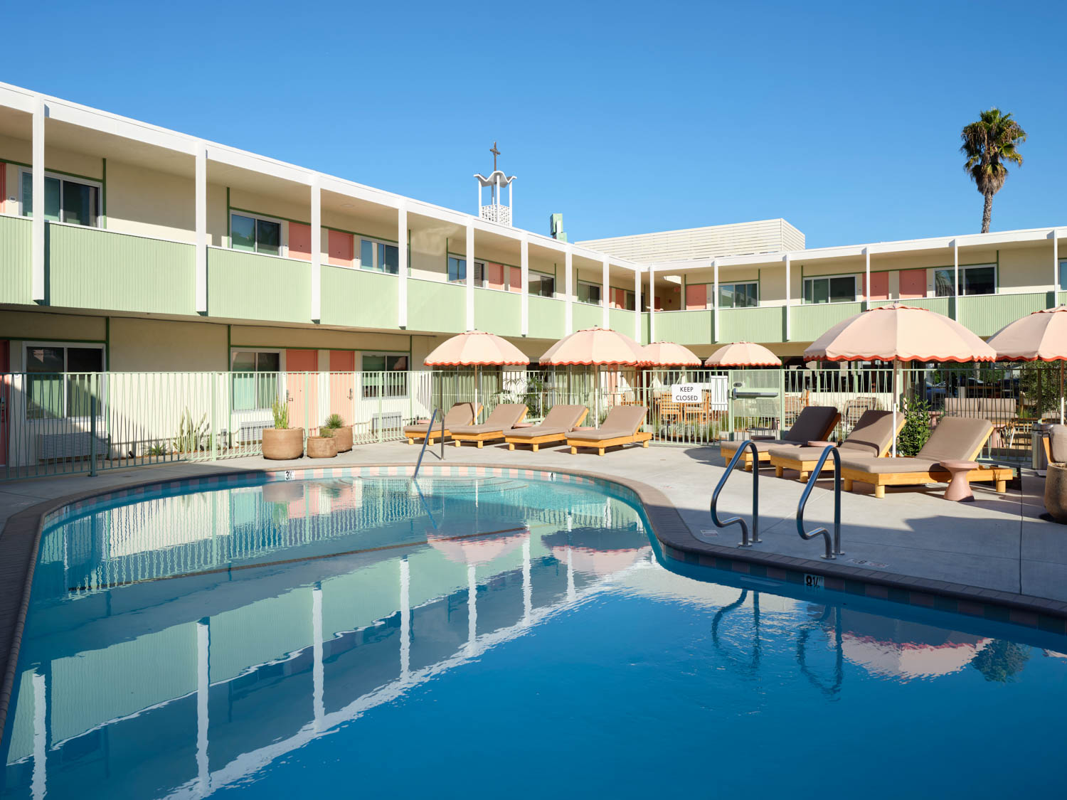 outdoor pool area with pink umbrellas