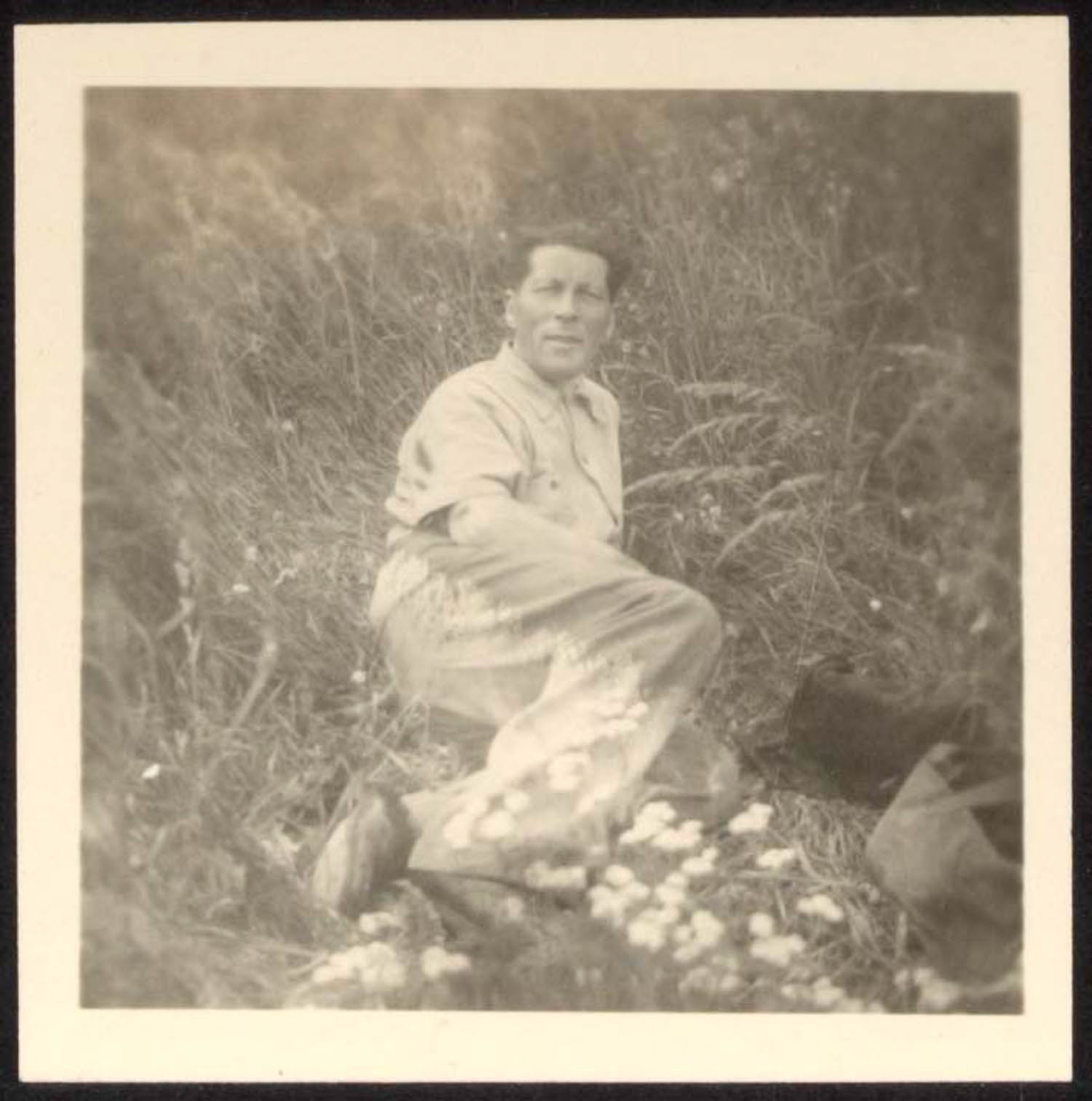 man sitting in field of flowers