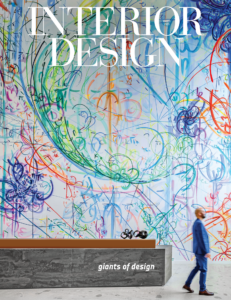 person standing by reception desk in front of mural