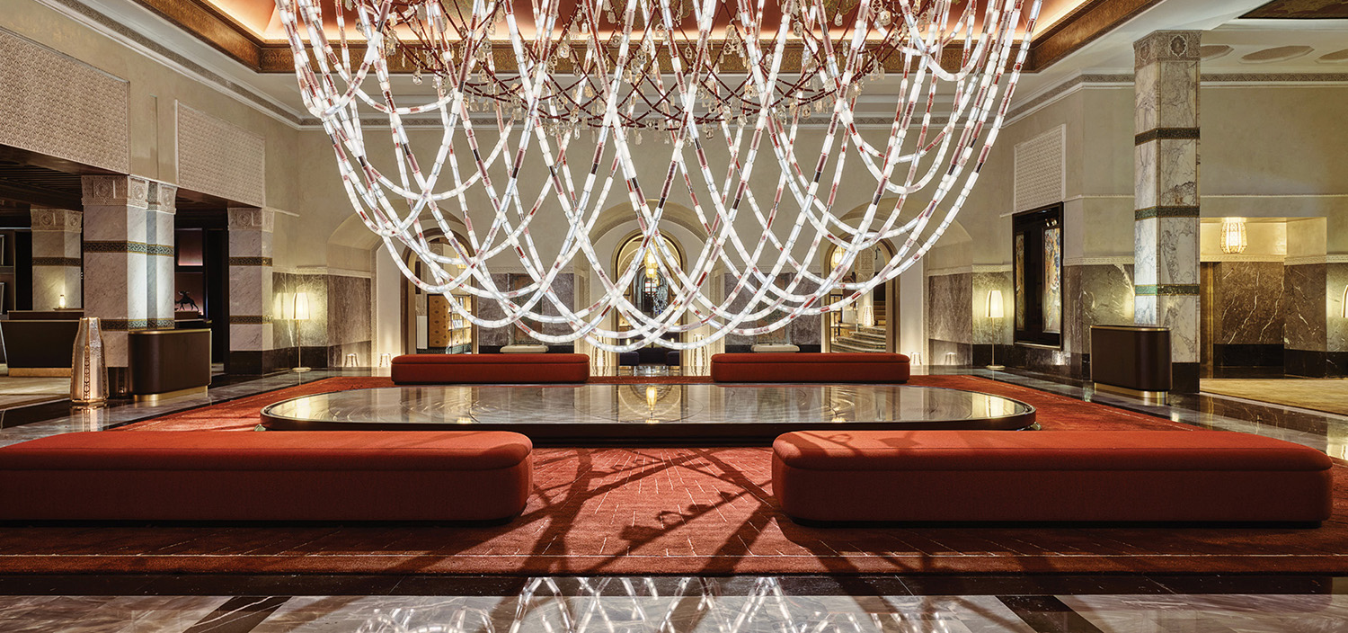 large light chandelier hanging over red couches