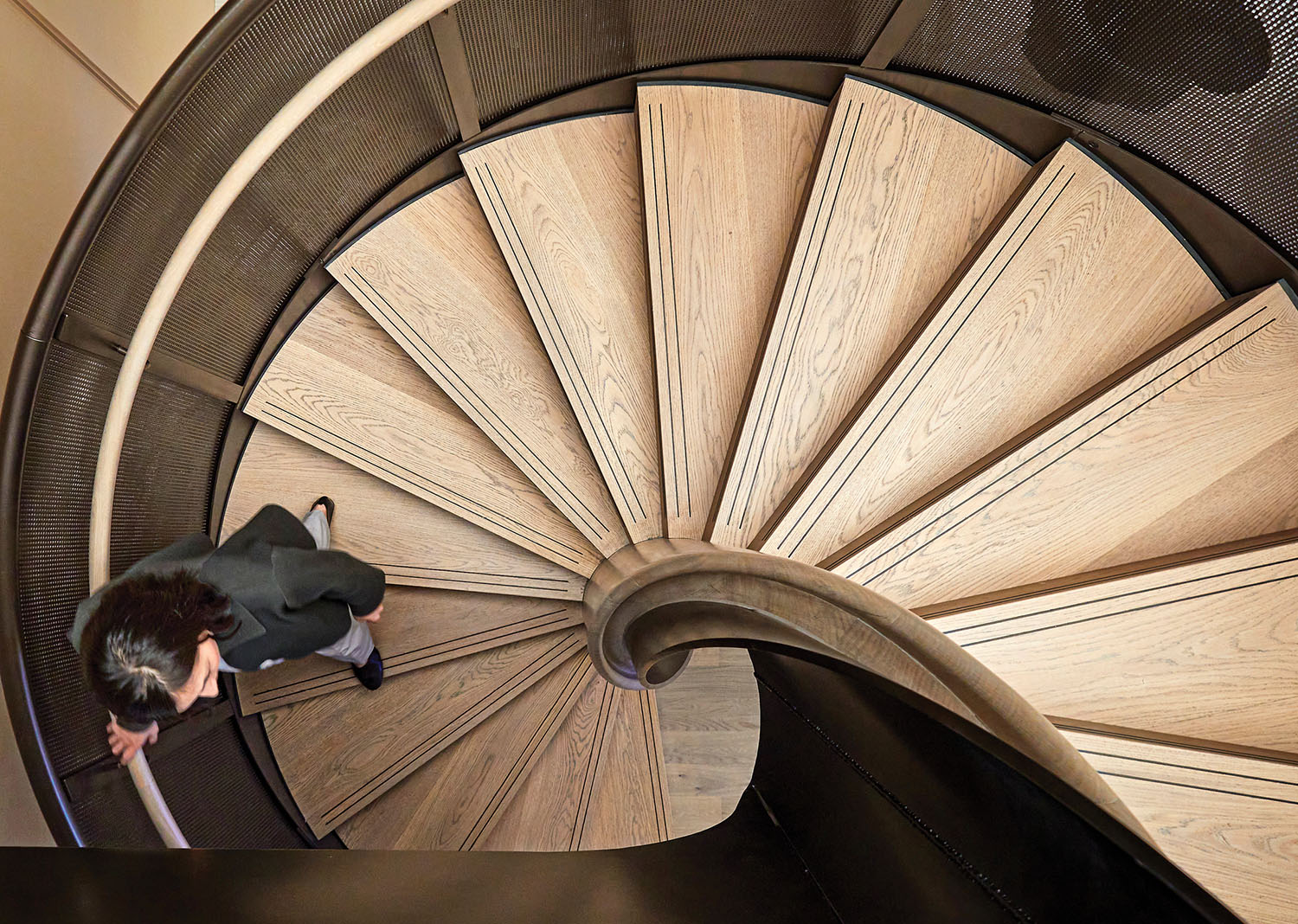 A man is walking up a spiral staircase