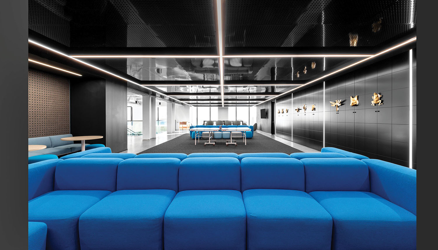 A blue couch in a room with a black ceiling.