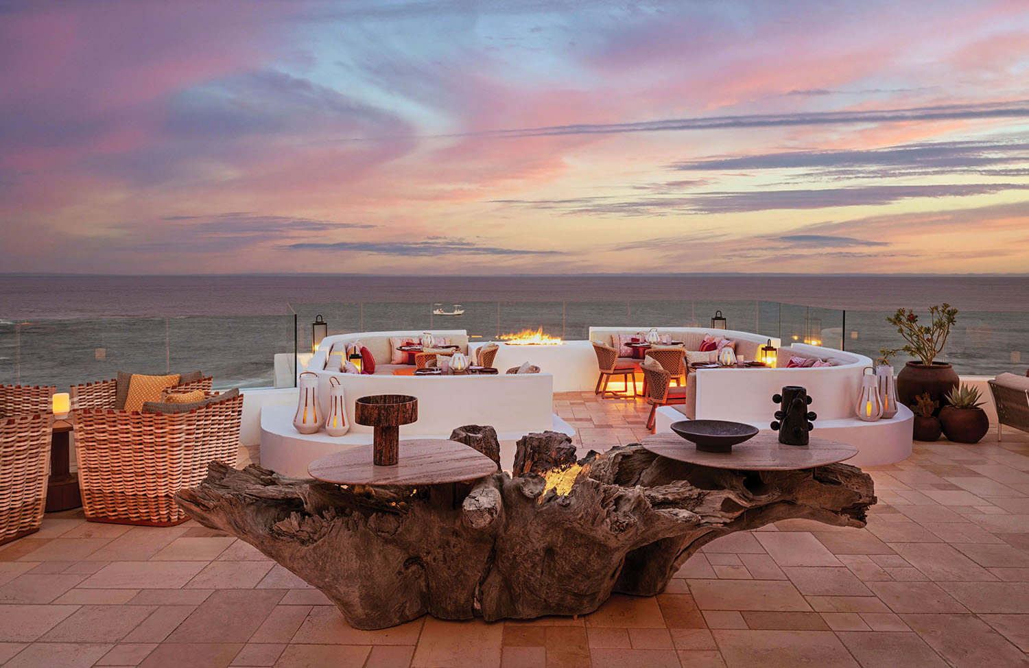 A large tree trunk holding lots of tables and a view to the sea