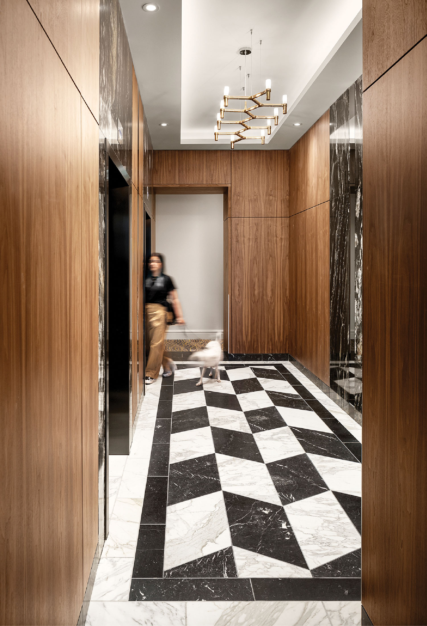 A man is walking through a hallway with a marble floor