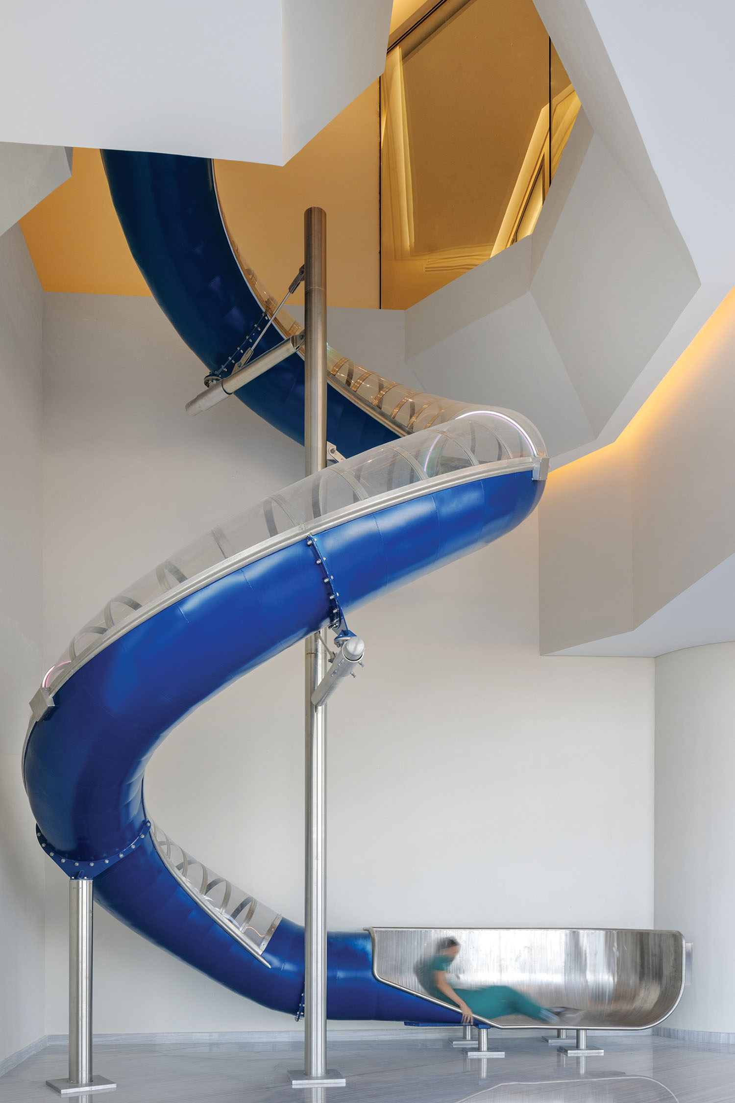 A blue and gold slide in a white room