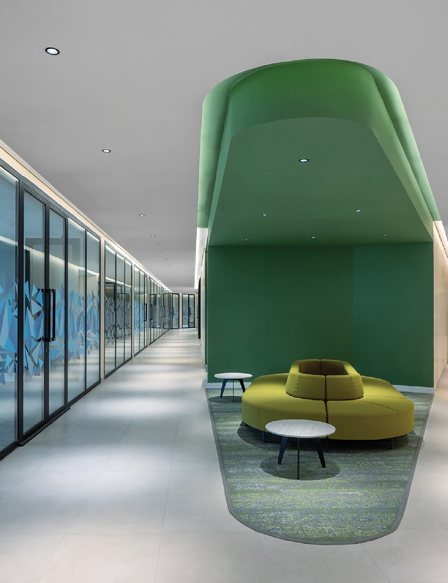 A green couch in a room with a wall of glass