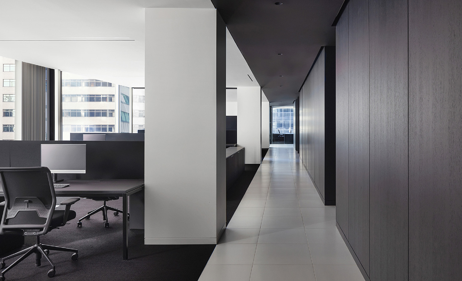 A long hallway with a desk and chairs.