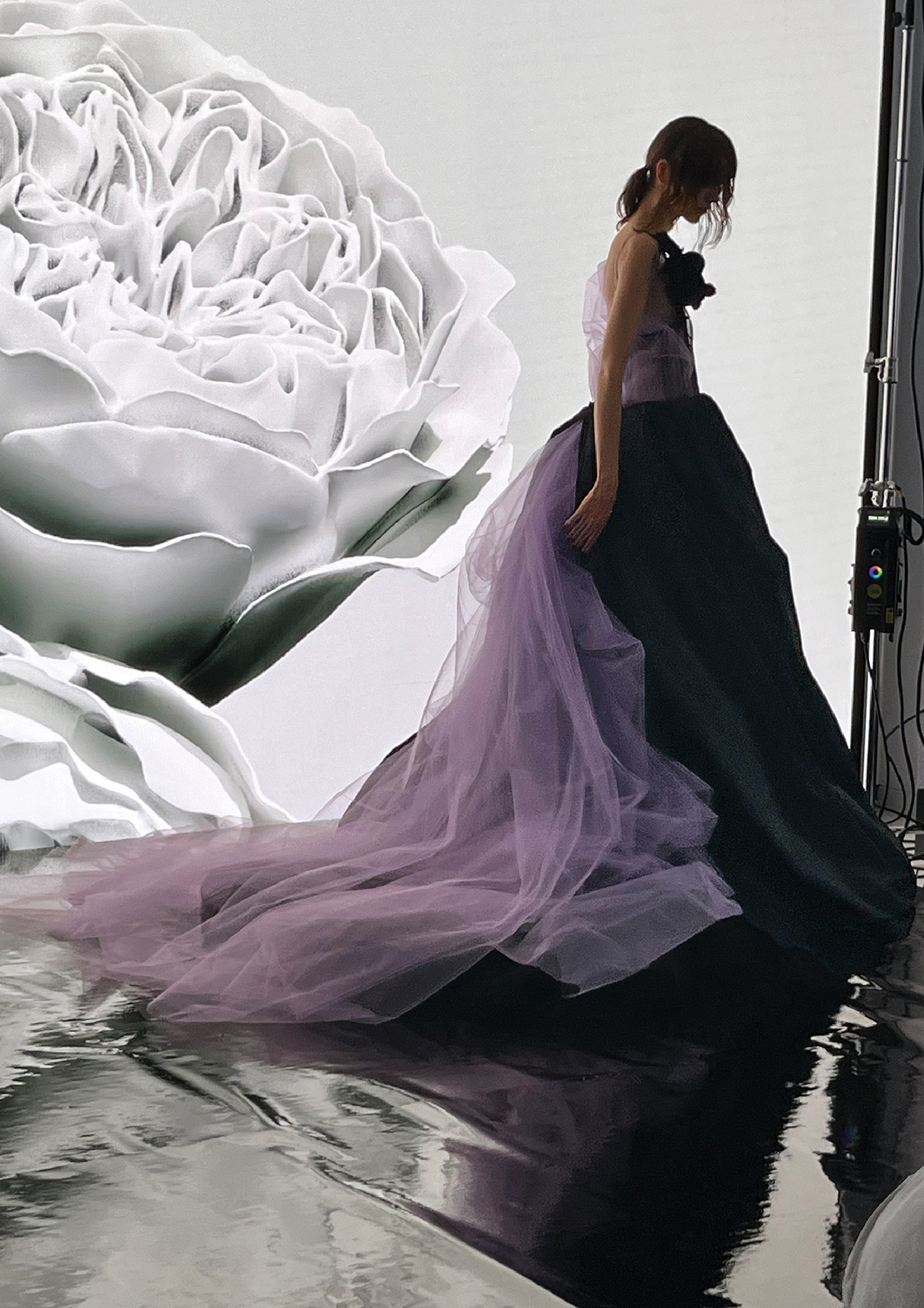 A woman in a dress is standing in a puddle.