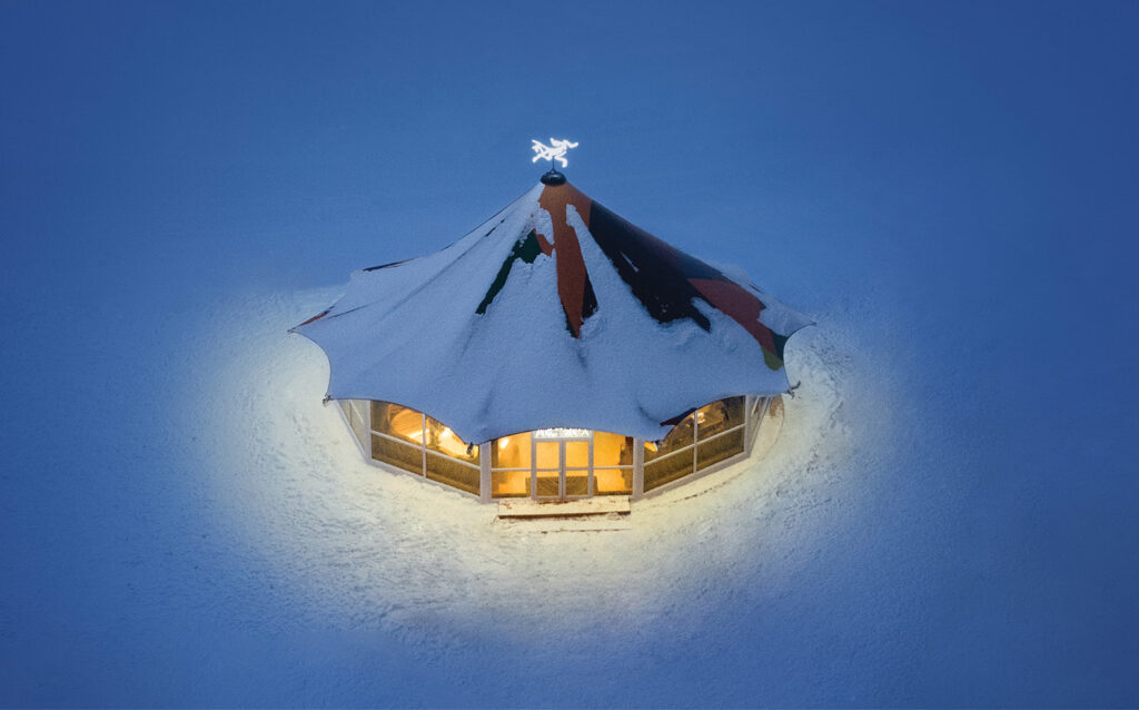 A small house with a snow covered roof.