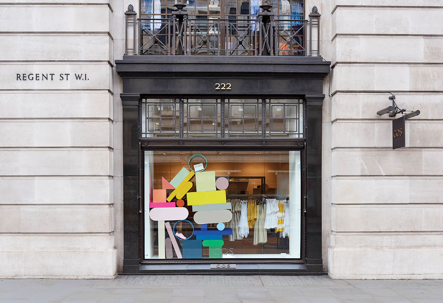 A store front with a large window with a painting of a woman.