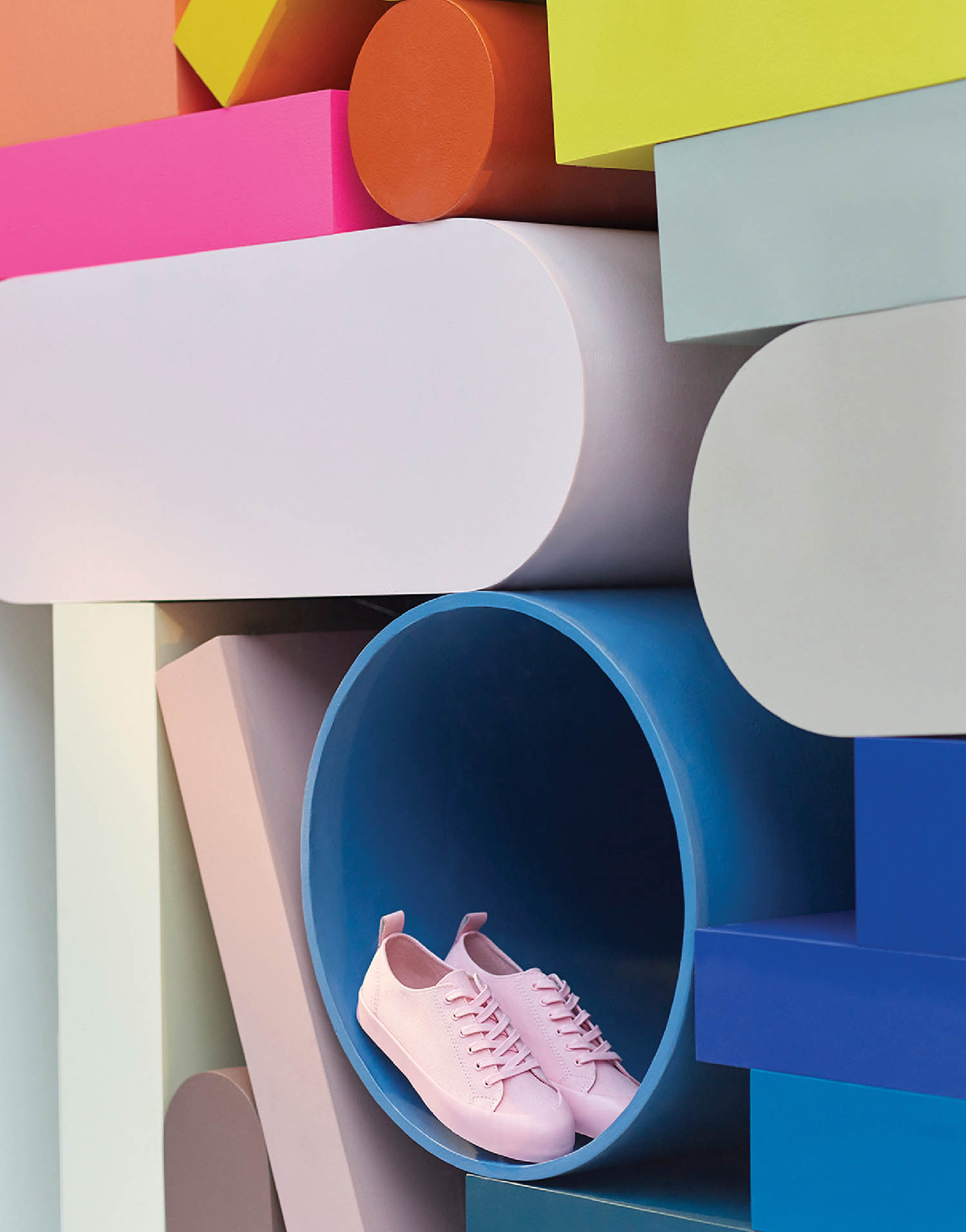 A pair of pink shoes sitting on top of colorful blocks.