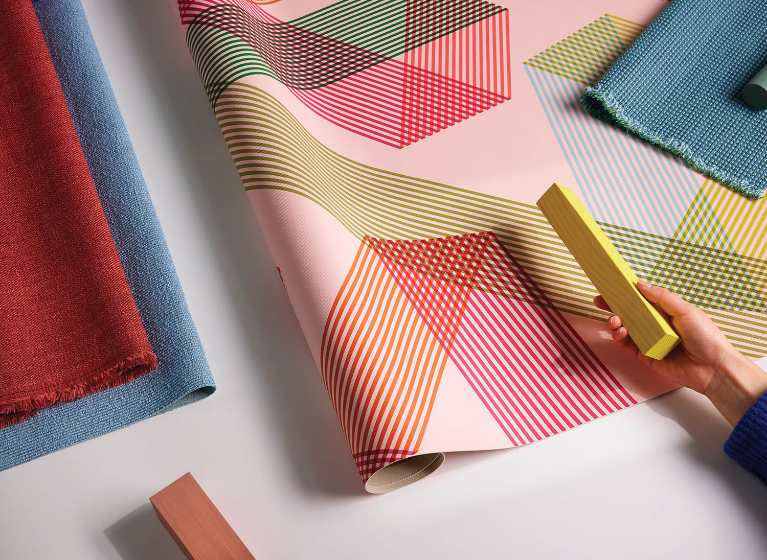 A person wrapping a piece of fabric on a table.