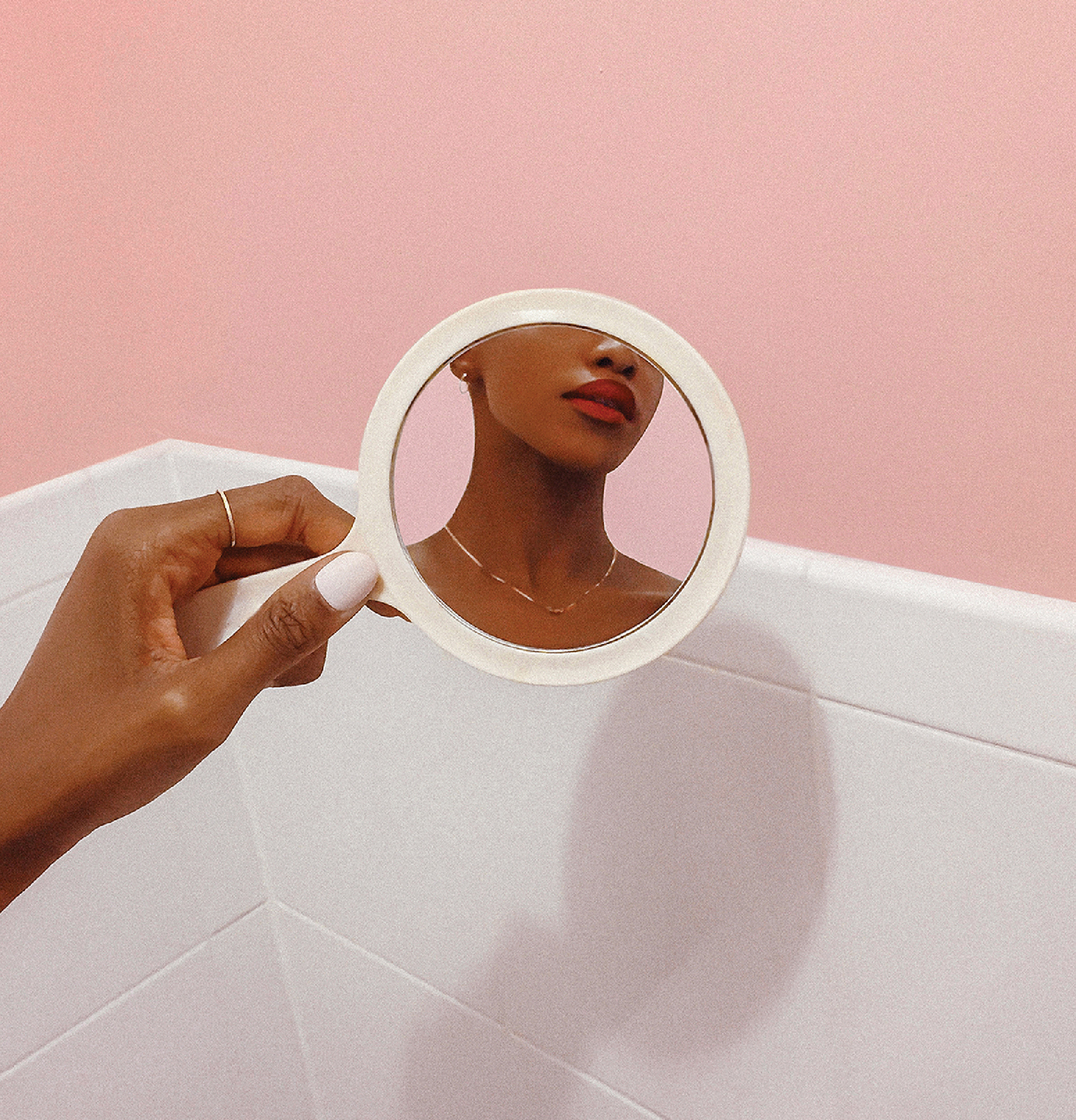 A woman is holding a mirror in her hand.